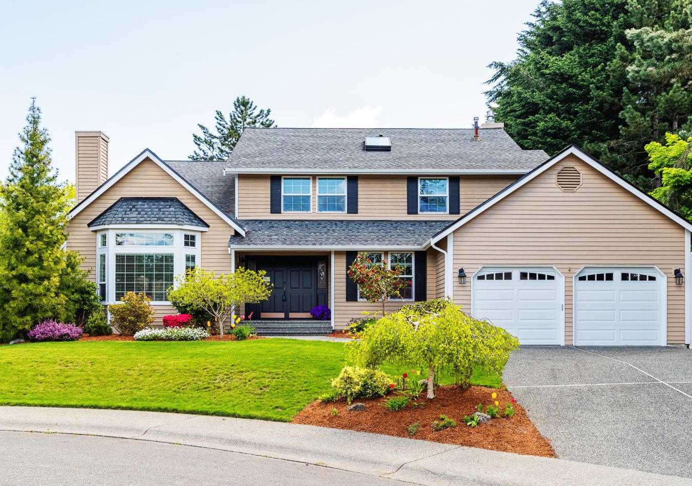 Single-family home with manicured landscaping and blue sky, representing home value